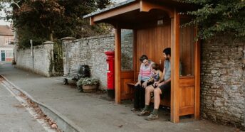 Family sat in a rural bus stop waiting for a local bus